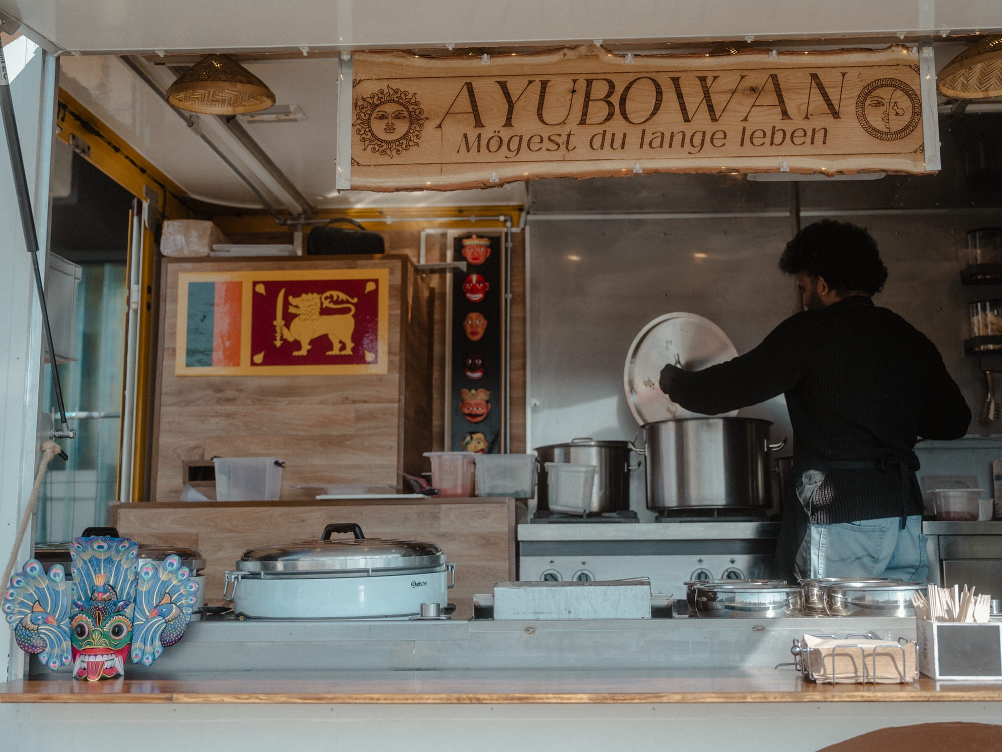 Blick in den Ceylon-Fusion-Foodtruck mit sri-lankischer Flagge und Ayubowan-Schild